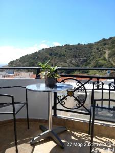 a table and chairs on a balcony with a view at Happy Days in Agia Galini