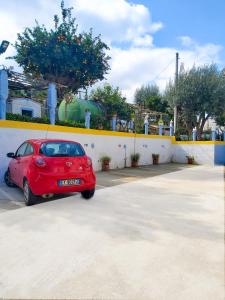 une voiture rouge garée sur un parking dans l'établissement Le Twins -Bed and Breakfast, à Tropea