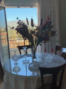 uma mesa de jantar com vasos e flores em Irini's House em Arménoi