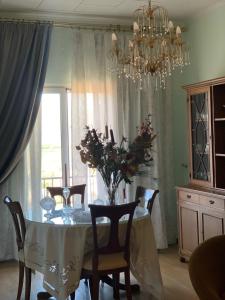 comedor con mesa, sillas y lámpara de araña en Irini's House, en Arménoi