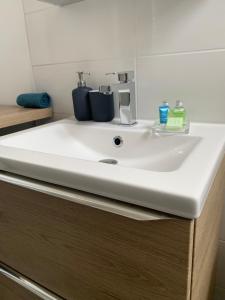 a bathroom sink with two cups on top of it at Le Logis Cantilien in Lamorlaye