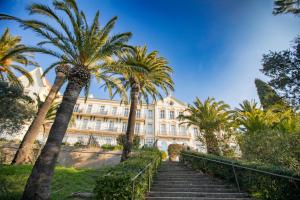 Un escalier mène à un bâtiment avec des palmiers. dans l'établissement Suite Tropez, Résidence de prestige, à La Croix-Valmer