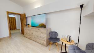 a living room with a large screen tv and a chair at Villa City Park in Košice