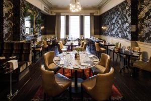 a restaurant with tables and chairs and a chandelier at 8 Beresford Street in Saint Helier Jersey