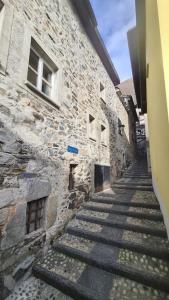 un antiguo edificio de piedra con escaleras junto a un edificio en Spacious house in village center with a view, en Ronco sopra Ascona