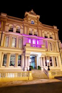 un gran edificio con luces moradas. en 8 Beresford Street en Saint Helier