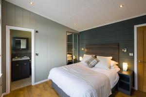 a bedroom with green walls and a large bed at Berth 6 on Upton Lake, Upton-upon-Severn Home on Water in Upton upon Severn