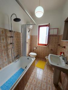 łazienka z wanną, umywalką i toaletą w obiekcie Margherita house sorrento w mieście Vico Equense