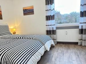 1 dormitorio con cama y ventana grande en Vogelnest, en Grömitz