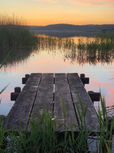 a dock on a lake with the sunset in the background at Ferienhaus Plauer See in Alt Schwerin