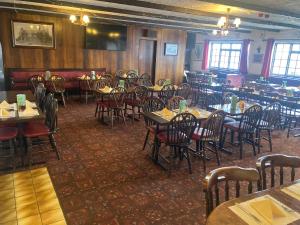 a dining room filled with tables and chairs at Green Acre Motel in North Cornelly