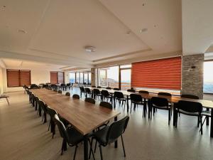 Großes Zimmer mit einem langen Tisch und Stühlen in der Unterkunft Magnolija Resort Ponikva in Kočani
