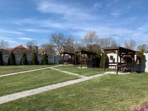 een park met twee picknickschuilplaatsen in het gras bij Pension Sara in Hevlín
