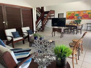 a living room with a couch and a table with a television at RESERVA DO PAIVA - A MELHOR CASA PARA TEMPORADA in Recife