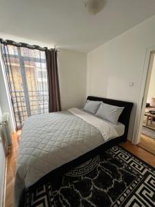 una camera da letto con un letto e una grande finestra di Apartment Dostojevski a Novi Sad