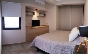 a bedroom with a bed and a flat screen tv at Altos Catamarca in San Fernando del Valle de Catamarca