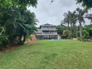 a large house with a swimming pool and a yard at Ballito Clarke Bay Beach House - family holiday letting in Ballito