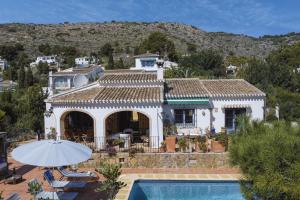 a villa with a swimming pool and a house at La Golondrina in Jávea