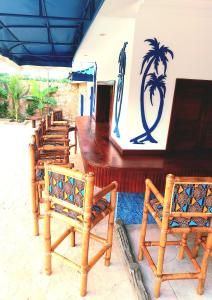 a row of wooden chairs sitting next to a bar at Blue Palm Resort Ghana in Abia