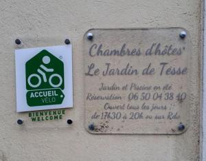 un panneau sur le côté d'un bâtiment avec un panneau sur celui-ci dans l'établissement Chambres et Table d'hôtes Le Jardin de Tesse, à Toulon
