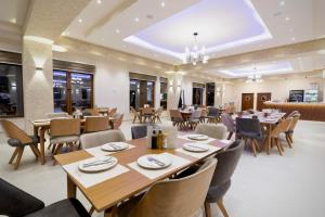 une salle à manger avec des tables et des chaises en bois dans l'établissement Magnolija Resort Ponikva, à Kotchani