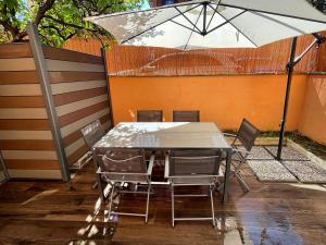 een tafel en stoelen met een parasol op een patio bij ROMA IS ALWAYS a GOOD IDEA in Rome