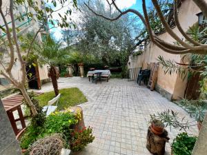 a patio with a table and some plants and trees at House with Garden in Noto