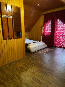 a room with two beds and a red wall at Pensiunea La Cristina in Sinaia