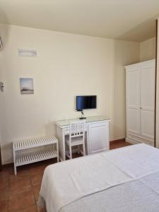 1 dormitorio con 1 cama y escritorio con TV en Masseria Casale Dei Fornici, en Polignano a Mare
