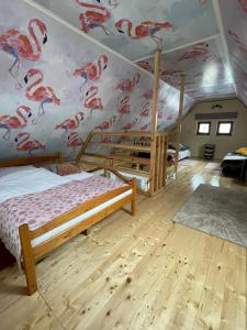 a bedroom with a mural of flamingos on the wall at Szmerkowa Chatynka z kominkiem i jacuzzi w Karkonoszach in Lubawka
