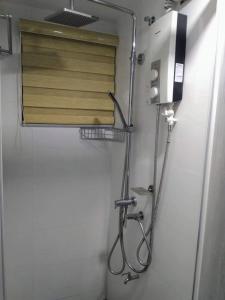 a shower in a bathroom with a wooden door at ADB Tower 1 bedroom with fast wifi and Netflix at Ortigas across Robinson's Galleria in Manila