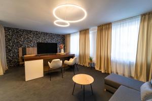uma sala de estar com uma secretária com cadeiras e um sofá em Hotel Zemplín em Trebišov