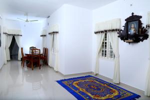 a living room with a table and a rug on the floor at Coconut Grove in Cochin