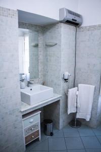 Baño blanco con lavabo y espejo en Antica Cittadella B&B, en Arezzo