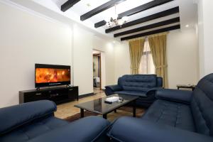 a living room with blue couches and a tv at Pearl Bahrain WLL in Manama