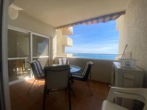 a balcony with a table and chairs and a view of the ocean at BENALBEACH COMPLEX in Benalmádena