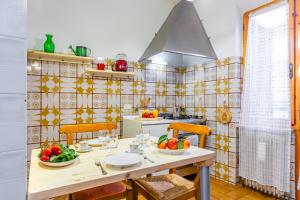 a kitchen with a table with fruits and vegetables on it at Pisa Airport Comfy Apartment - Private Parking in Pisa