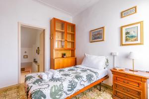 a bedroom with a bed and a dresser with a night stand at Pisa Airport Comfy Apartment - Private Parking in Pisa