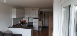 eine Küche mit weißen Schränken und einer Arbeitsplatte in der Unterkunft Modern Apartment in Zenica in Zenica