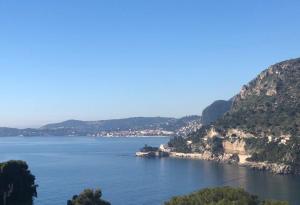uma vista para um grande corpo de água com montanhas em Une terrasse sur Monaco logement 2 chambre em Beausoleil