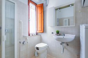 a bathroom with a toilet and a sink and a mirror at Pisa Airport Comfy Apartment - Private Parking in Pisa