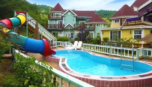 a large pool with a slide in front of a house at Olive Vanilla Pension in Gyeongju