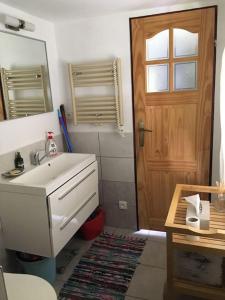 a bathroom with a sink and a mirror and a door at Cozy mountain cottage with terrace in Dolni Lomna in Dolní Lomná