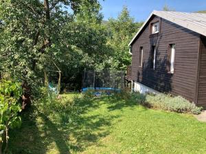 a yard next to a house with a fence at Cozy mountain cottage with terrace in Dolni Lomna in Dolní Lomná