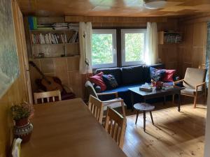 a living room with a blue couch and a table at Cozy mountain cottage with terrace in Dolni Lomna in Dolní Lomná