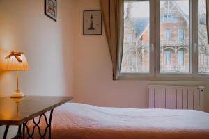 Saint-Martin-aux-Buneaux的住宿－Front de Mer - Villa Mozart，一间卧室配有一张带桌子和窗户的床