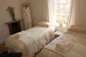 a bedroom with two beds and a window at Moon in the Apple Tree in Glastonbury