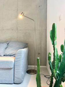 a room with a couch and a lamp and a cactus at Weinberg-Design-Apartment Stuttgart-Fellbach in Fellbach