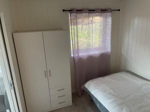 1 dormitorio con 1 cama, vestidor y ventana en Strandveien 71, en Skjervøy