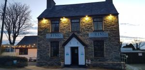 un edificio de piedra con una señal de rey en él en Ensuite Bed And Breakfast Rooms At The Ring Pub, en Gwredog